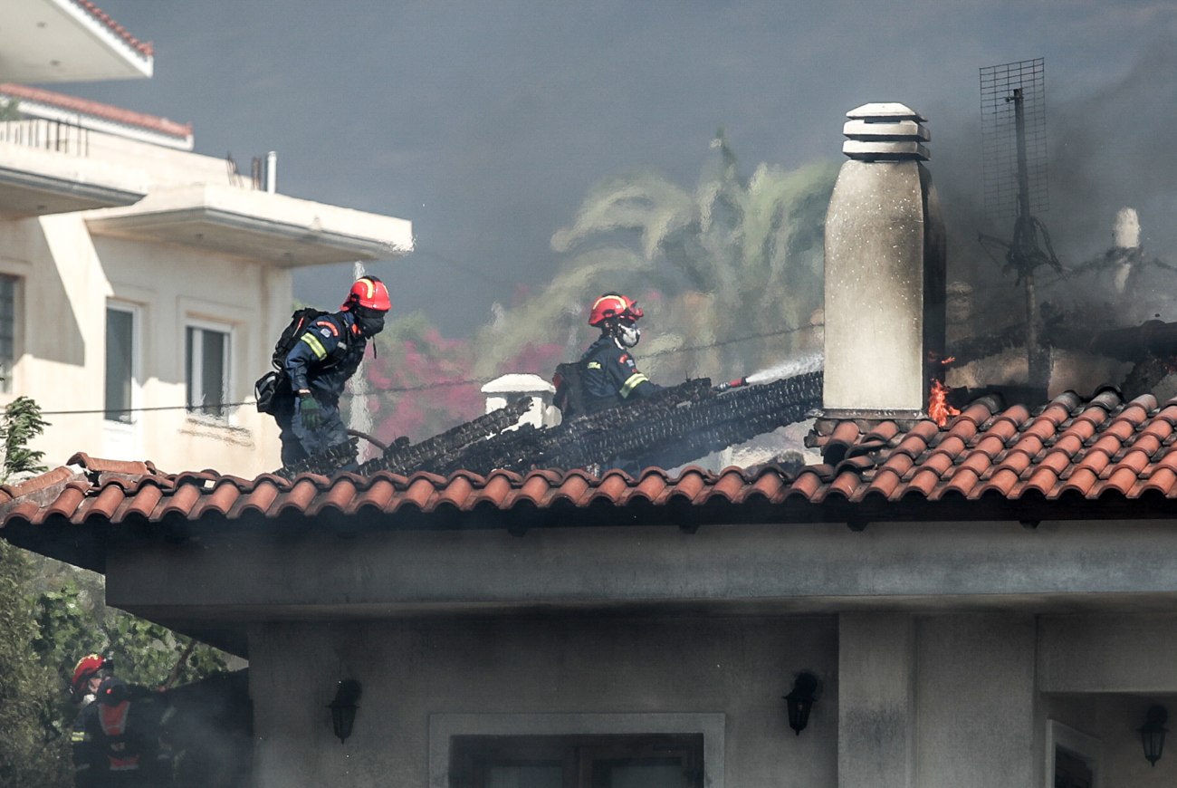 Παλαιά Φώκαια: Πυροσβέστης σκαρφαλώνει σε σκεπή για να σώσει φλεγόμενο σπίτι