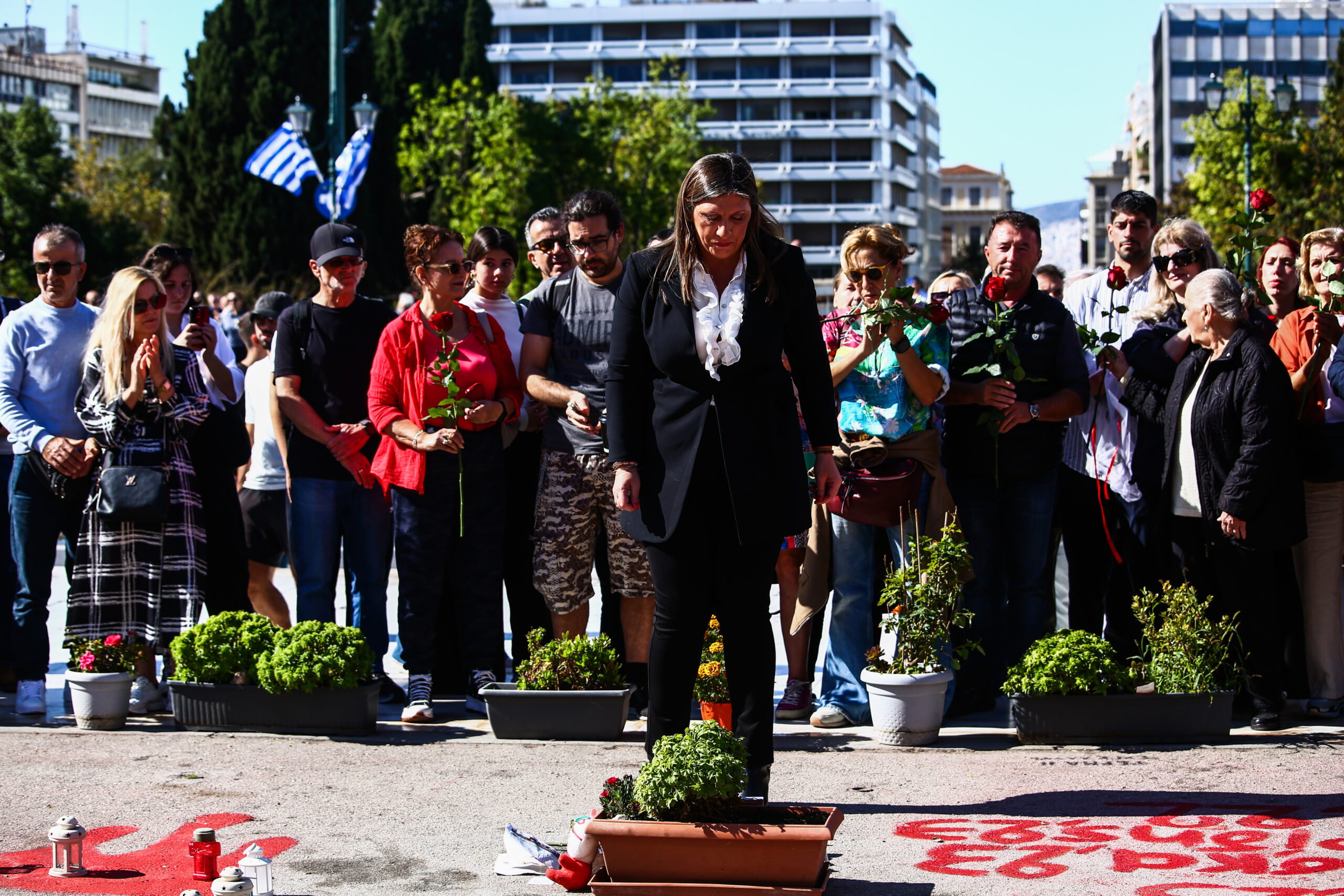 Σύνταγμα: Μετά την παρέλαση συγγενείς των θυμάτων των Τεμπών άφησαν λουλούδια στο σημείο με τα χαραγμένα ονόματα